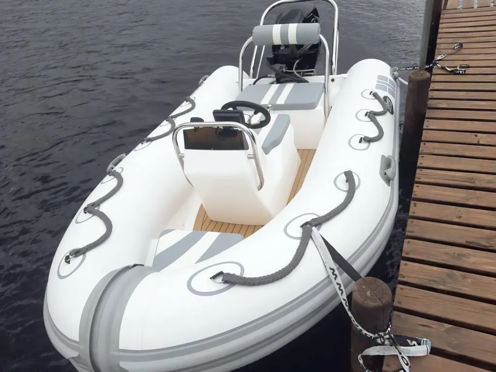White and grey anchored inflatable boat