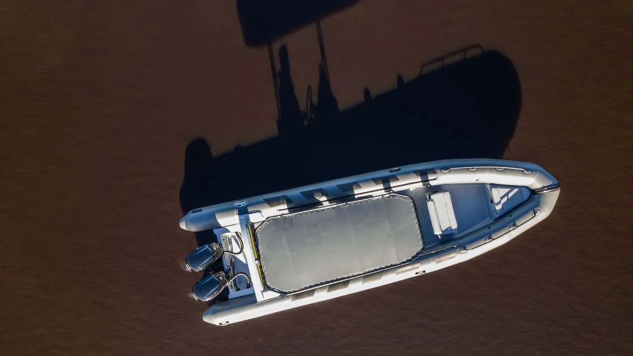 Top view of an inflatable boat on brown waters