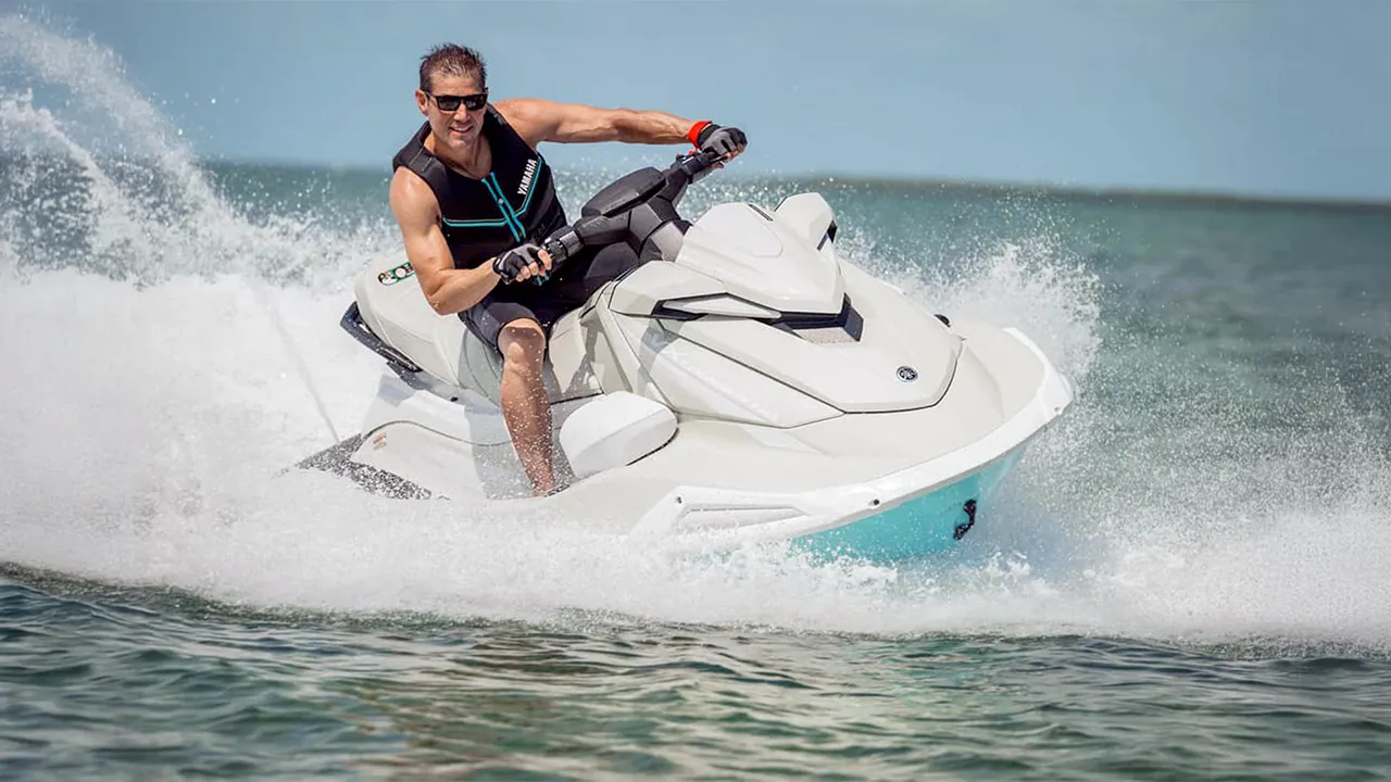Man speeding on white and turquoise jet ski