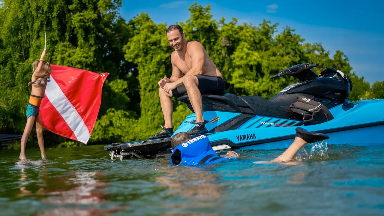 Man sitting on a stationery cyan jet ski