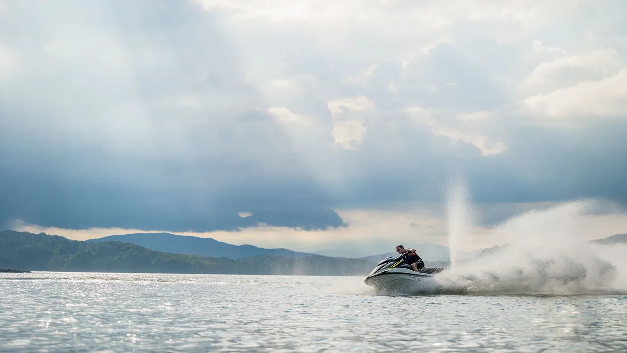 Man racing on jet ski with rear water spout for visibility